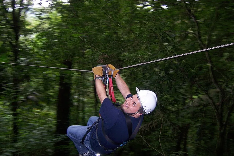 Ormanlık bir alanda zipline yapan katılımcı